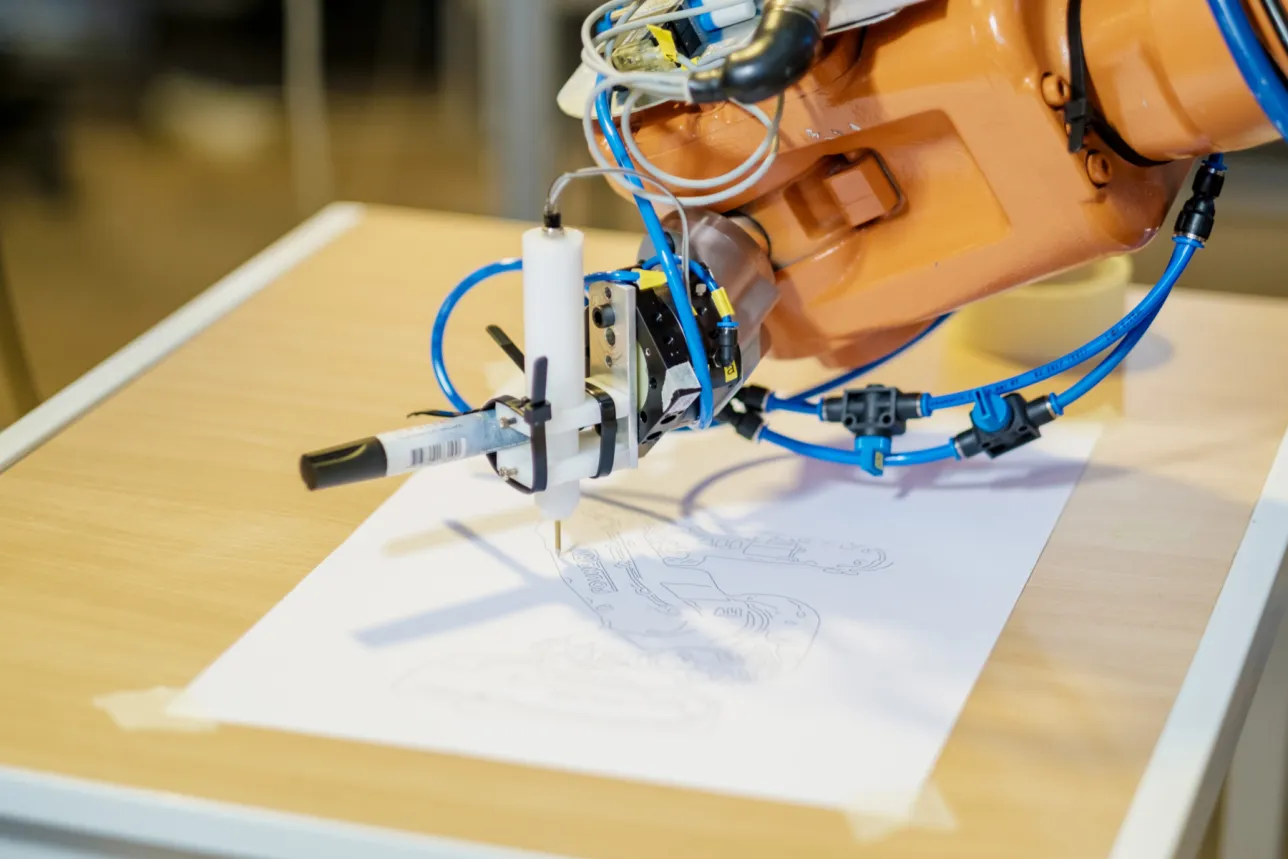Robot hand drawing on paper. Photo.
